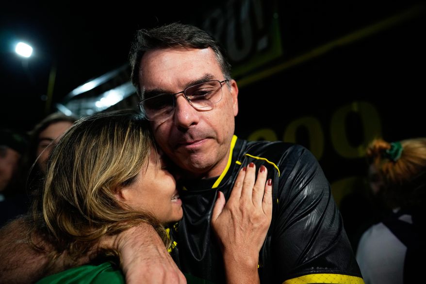 Flavio Bolsonaro, son of ex-President Jair Bolsonaro, hugs a supporter during a vigil outside the former president's residence in Brasília, Brazil, Saturday, Nov. 22, 2025, after his father's arrest earlier in the day, carried out days before he was set to start serving his 27-year sentence for leading a coup attempt. (AP Photo/Eraldo Peres)