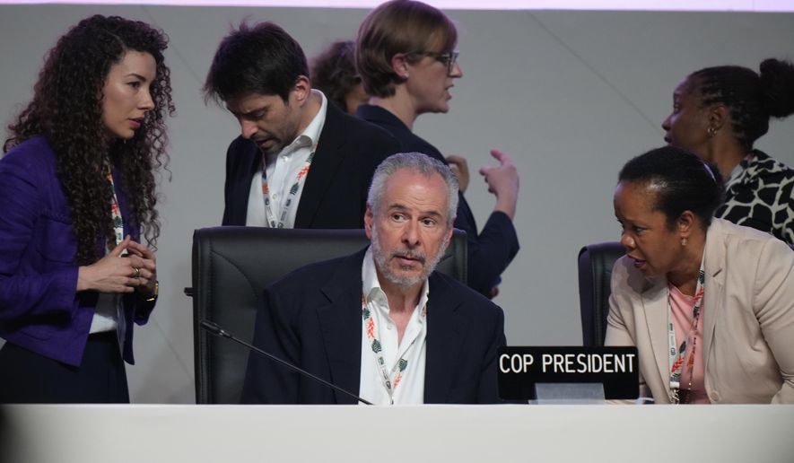 André Corrêa do Lago, COP30 president, center, arrives for a plenary session at the COP30 U.N. Climate Summit, Saturday, Nov. 22, 2025, in Belem, Brazil. (AP Photo/Fernando Llano)