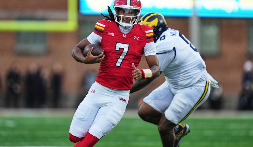 Maryland quarterback Malik Washington (7) runs the ball past Michigan defensive tackle Tré Williams (0) during the first half of an NCAA college football game, Saturday, Nov. 22, 2025, in College Park, Md. (AP Photo/Stephanie Scarbrough)