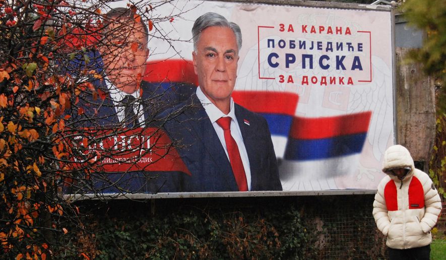 A man walks past an election billboard showing Bosnian Serb leader Milorad Dodik, and SNSD party's candidate Sinisa Karan, reading: "For Karan, Republic of Srpska will win, For Dodik.", two days before early presidential elections in the Bosnian town of Banja Luka, 240 kms northwest of Sarajevo, Friday, Nov. 21, 2025. (AP Photo/Radivoje Pavicic)