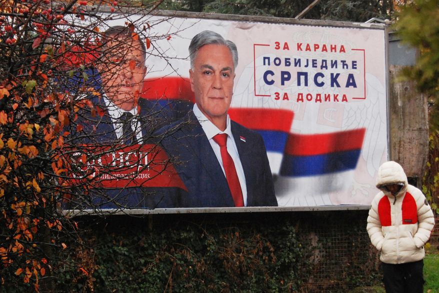 A man walks past an election billboard showing Bosnian Serb leader Milorad Dodik, and SNSD party's candidate Sinisa Karan, reading: "For Karan, Republic of Srpska will win, For Dodik.", two days before early presidential elections in the Bosnian town of Banja Luka, 240 kms northwest of Sarajevo, Friday, Nov. 21, 2025. (AP Photo/Radivoje Pavicic)