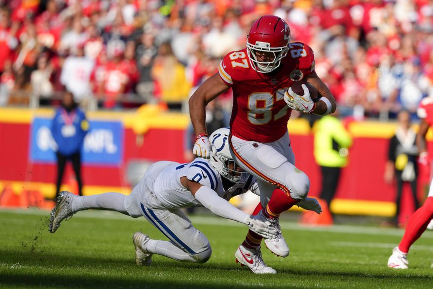 Kansas City Chiefs tight end Travis Kelce (87) is tackled by Indianapolis Colts safety Camryn Bynum (0) during the first half of an NFL football game Sunday, Nov. 23, 2025, in Kansas City, Mo. (AP Photo/Ed Zurga)