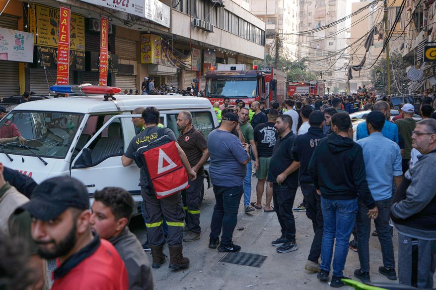 People and Civil Defence workers gather at the site where an Israeli airstrike hit an apartment building on Dahiyeh in the southern suburb of Beirut, Sunday Nov. 23, 2025. (AP Photo/Bilal Hussein)