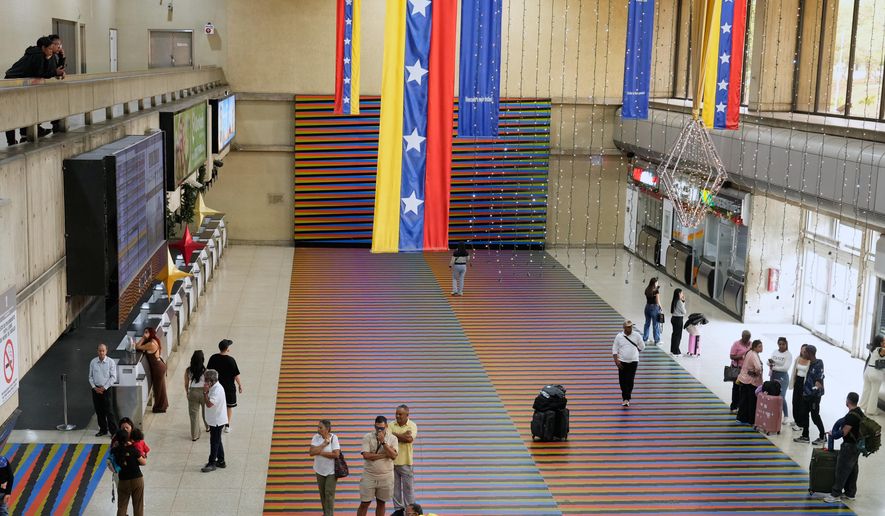 Travelers wait in the main hall of the Simon Bolivar Maiquetia International Airport in Maiquetia, Venezuela, Sunday, Nov. 13, 2025, after several international airlines canceled flights following a warning from the U.S. Federal Aviation Administration about a hazardous situation in Venezuelan airspace. (AP Photo/Ariana Cubillos)