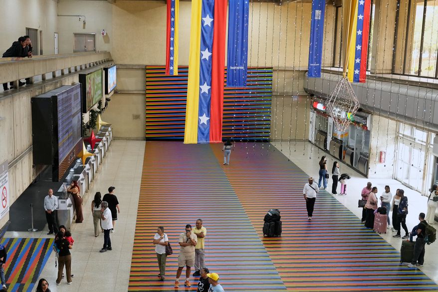 Travelers wait in the main hall of the Simon Bolivar Maiquetia International Airport in Maiquetia, Venezuela, Sunday, Nov. 13, 2025, after several international airlines canceled flights following a warning from the U.S. Federal Aviation Administration about a hazardous situation in Venezuelan airspace. (AP Photo/Ariana Cubillos)