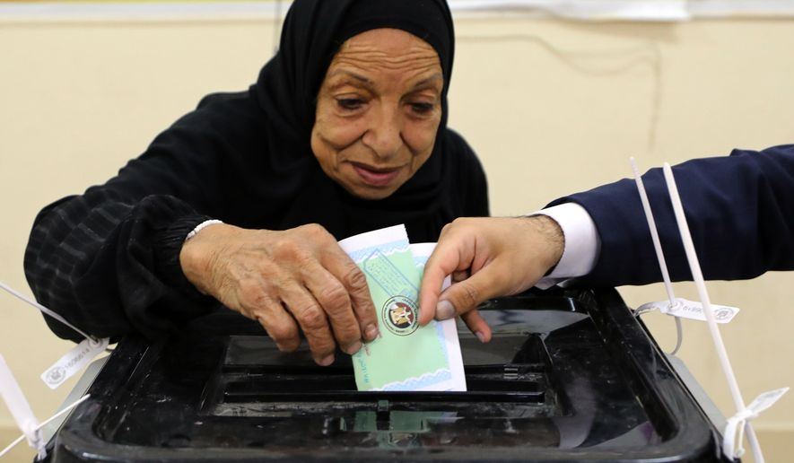 An Egyptian woman casts her ballot during the second phase of parliamentary elections in Cairo, Egypt, Monday, Nov. 24, 2025. (AP Photo/Khaled Elfiqi)