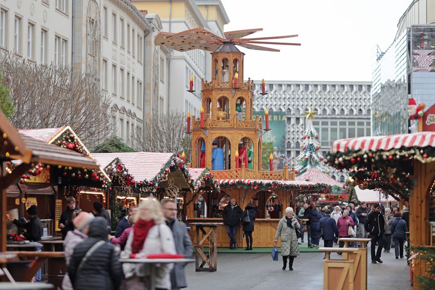 Visitors walk through the Magdeburg Christmas market, in Magdeburg, Germany, Thursday, Nov. 20, 2025. (Matthias Bein/dpa via AP)