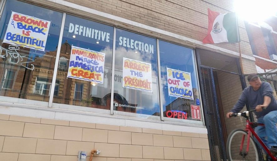 FILE - A bicyclist passes Definitive Selection clothing store, one of many businesses in the predominantly Latino neighborhood that has seen a slowdown in foot traffic since President Donald Trump's threats of a federal law enforcement intervention, Sept. 5, 2025, in Chicago. (AP Photo/Mark Vancleave, File)