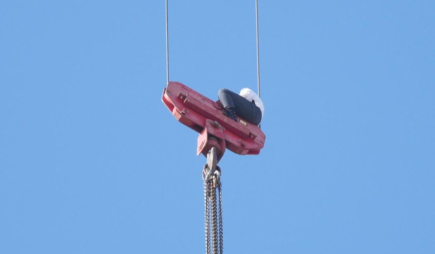 A teenager is seen trapped on a crane platform atop a skyscraper, where he dangled 36 stories up in the air for seven hours before being rescued, in Jerusalem Monday, Nov. 24, 2025. (AP Photo/Ohad Zwigenberg)
