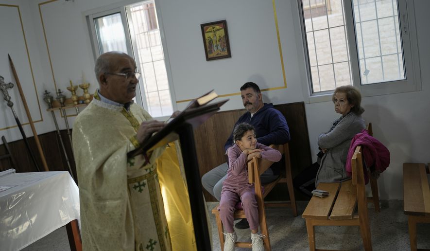 Priest Maurice El Khoury, left, leads Sunday Mass inside a room usually used as a residence for visiting bishops next to St. George Melkite Catholic Church, which was destroyed in an Israeli airstrike, in the town of Dardghaya, southern Lebanon, Sunday, Nov. 16, 2025. (AP Photo/Hassan Ammar)