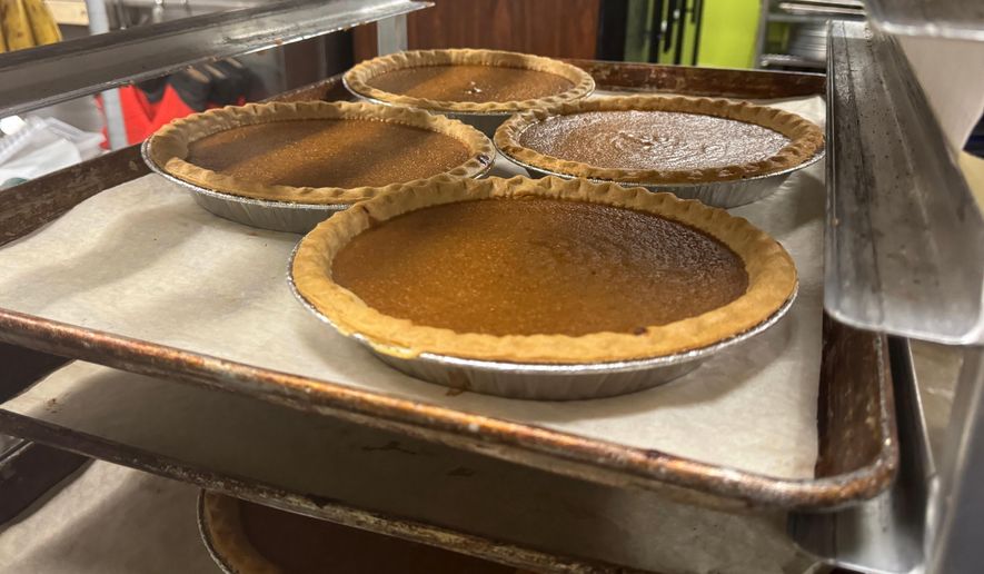 Pies, fresh out of the oven, cool on a baking rack on Friday, Nov. 21, 2025, in Flowood, Miss. (AP Photo/Sophie Bates)