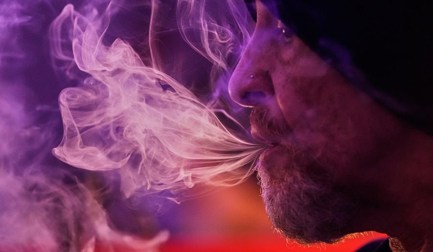 Miguel Laboy smokes cannabis, Oct. 3, 2025, in Brookline, Mass. (AP Photo/Robert F. Bukaty)