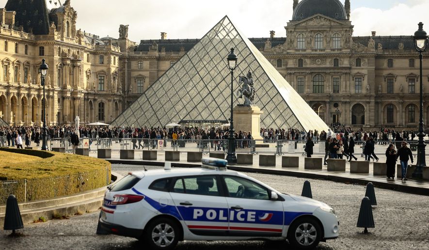 A police car parks in the courtyard of the Louvre museum, one week after the robbery, on Oct. 26, 2025, in Paris. (AP Photo/Thomas Padilla, File)