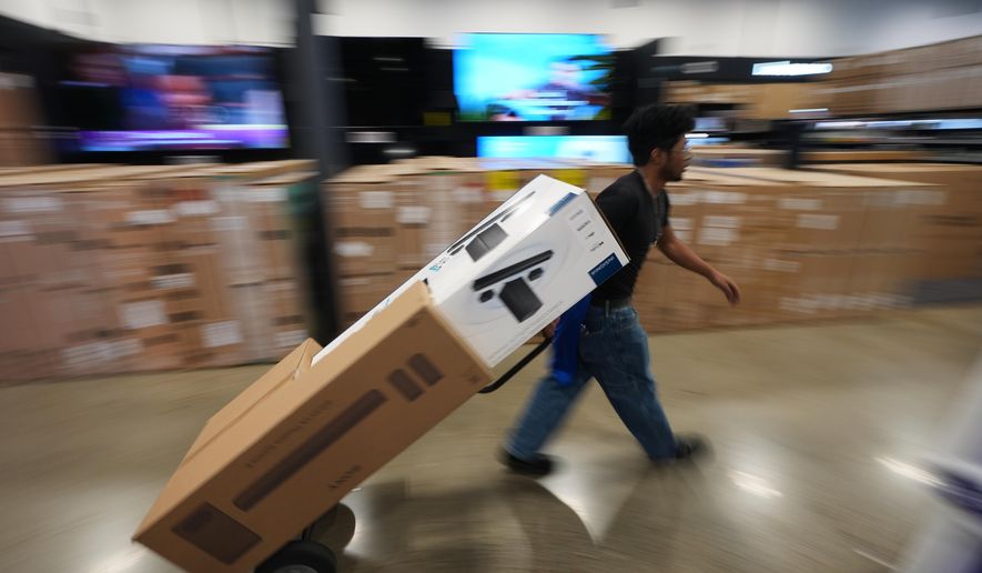 A Best Buy employee hauls early Black Friday sale items at Best Buy Thursday, Nov. 20, 2025, in San Diego. (AP Photo/Gregory Bull)