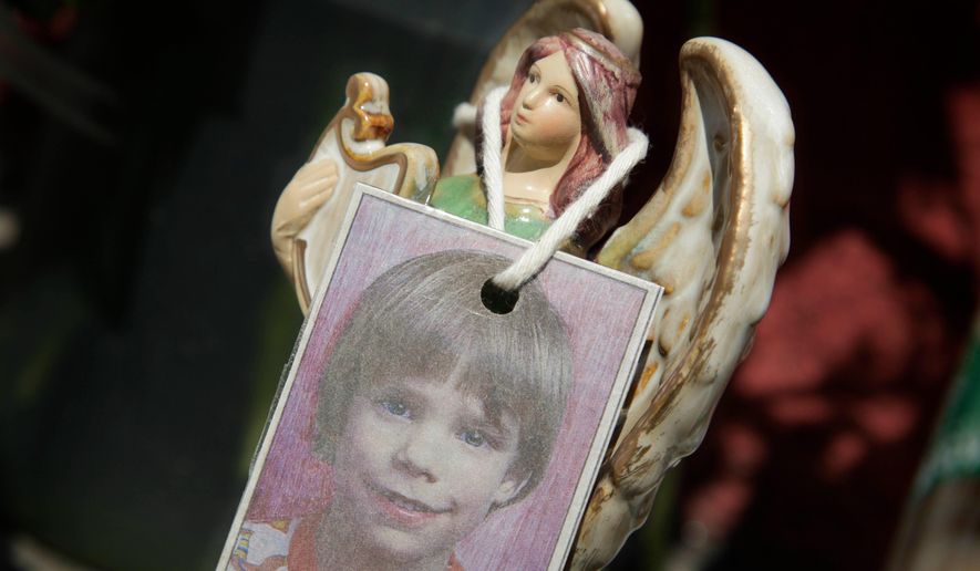 A photograph of Etan Patz hangs on an angel figurine, as part of a makeshift memorial in the SoHo neighborhood of New York, May 28, 2012. (AP Photo/Mark Lennihan, File)