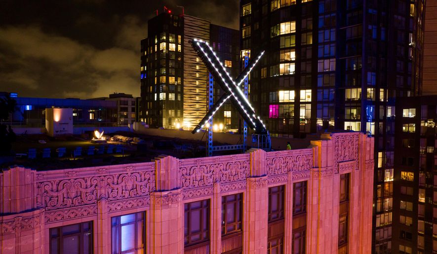 Workers install lighting on an "X" sign atop the company headquarters in downtown San Francisco, July 28, 2023. (AP Photo/Noah Berger, File)
