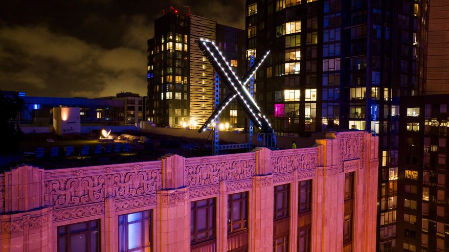Workers install lighting on an "X" sign atop the company headquarters in downtown San Francisco, July 28, 2023. (AP Photo/Noah Berger, File)