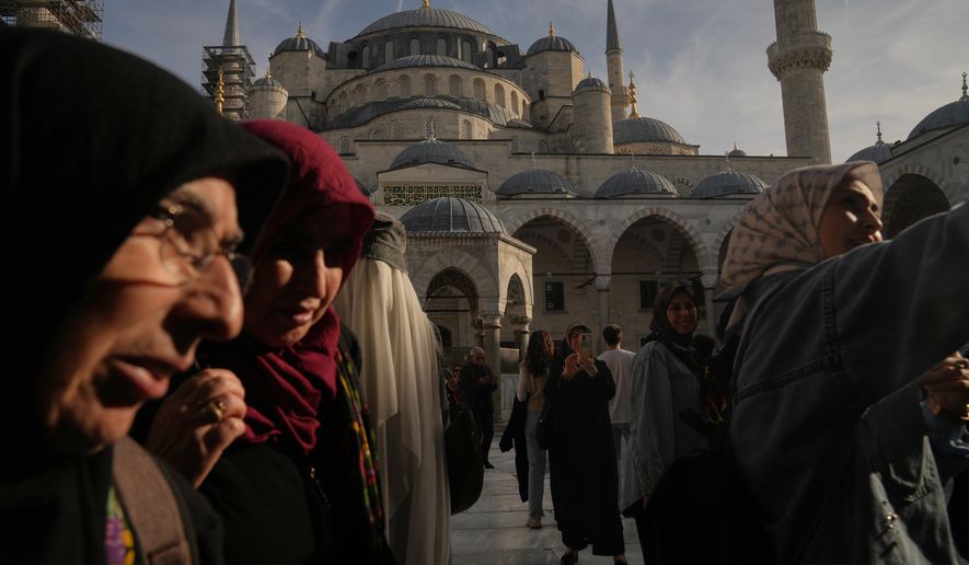 Locals and tourists visit the Ottoman-era Sultan Ahmed or Blue Mosque, in Istanbul, Turkey, Friday, Nov. 21, 2025, ahead of the visit of Pope Leo XIV to Turkey. (AP Photo/Francisco Seco)