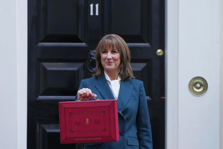 Britain's Chancellor of the Exchequer Rachel Reeves poses on the doorstep of 11 Downing Street with her ministerial red box before heading to the House of Commons to deliver her Budget speech in London, Wednesday, Nov. 26, 2025. (AP Photo/Kirsty Wigglesworth)