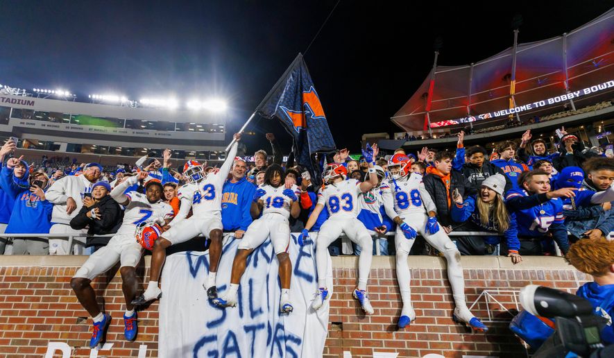 FILE -Florida players and fans celebrate after defeating Florida State in an NCAA college football game, Nov. 30, 2024, in Tallahassee, Fla. (AP Photo/Colin Hackley, File)