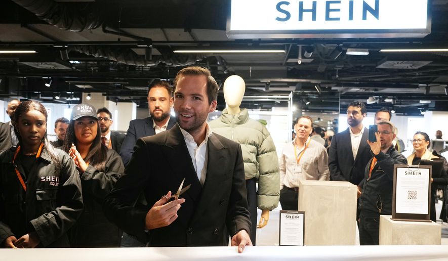 The director of the Bazar de l'Hotel de Ville (BHV) department store Karl-Stephane Cottendin prepares to cut the ribbon at the opening Shein's first physical store in Paris, Wednesday, Nov. 5, 2025. ( Dimitar Dilkoff, Pool via AP)