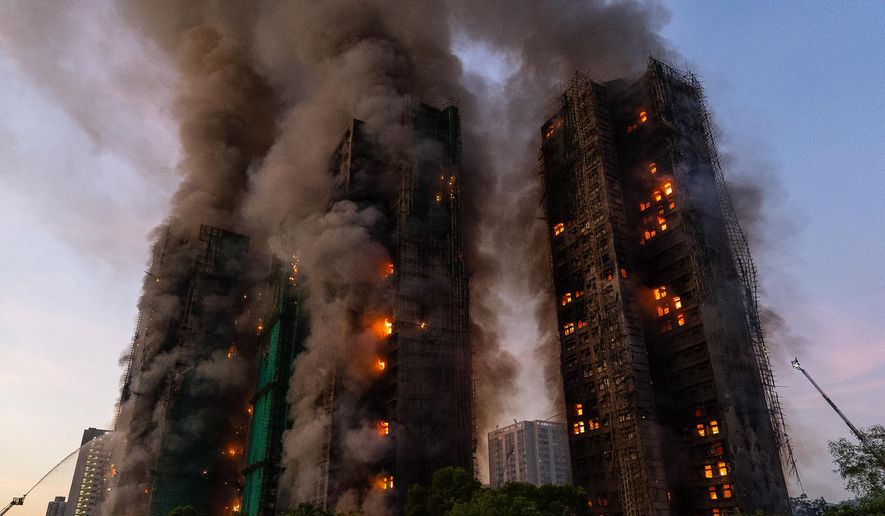 Smoke rises after a fire broke out at Wang Fuk Court, a residential estate in the Tai Po district of Hong Kong's New Territories on Wednesday, Nov. 26 2025. (AP Photo/Chan Long Hei)