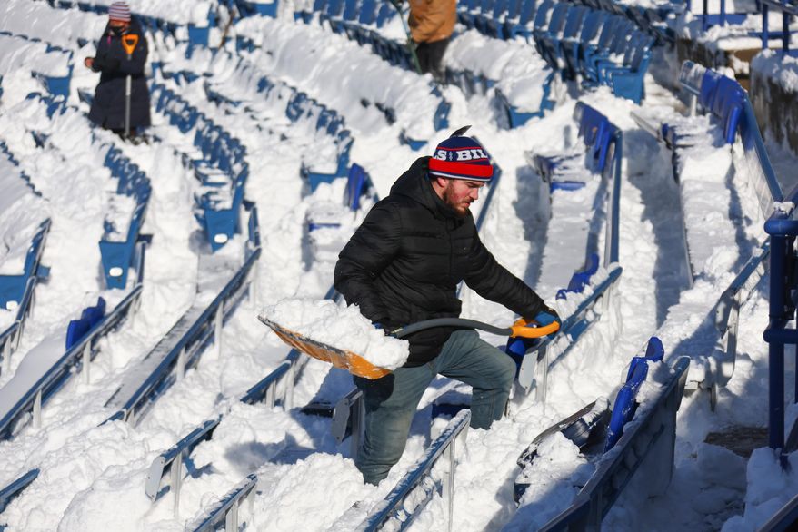FILE - A stadium worker clears snow from seats before an NFL wild-card playoff football game between the Buffalo Bills and the Pittsburgh Steelers, Jan. 15, 2024, in Buffalo, N.Y. (AP Photo/Jeffrey T. Barnes, File)