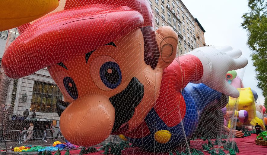 People pass Mario balloon during inflation for the 99th Macy's Thanksgiving Day Parade Wednesday, Nov. 26, 2025, in New York. (AP Photo/Frank Franklin II)