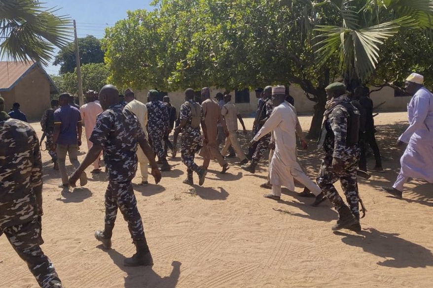Police and government officials walk past St. Mary's Catholic Primary and Secondary School where gunmen on Friday abducted children and staff in Papiri community, Nigeria, Tuesday, Nov.25, 2025. (AP Photo/Yunusa Umar )