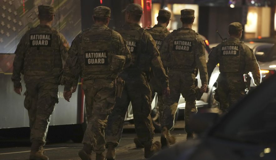 Nation Guard move through the area following the shooting of two National Guard soldiers near the White House Wednesday, Nov. 26, 2025, in Washington. (AP Photo/Mark Schiefelbein)