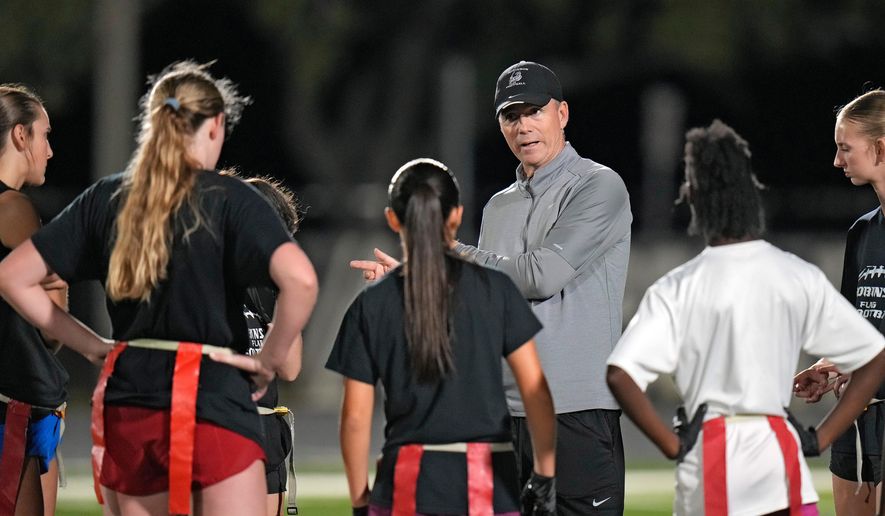 Robinson High School girls flag football coach Joshua Saunders talks to some of his players during a practice, Wednesday, Nov. 5, 2025, in Tampa, Fla. (AP Photo/Chris O'Meara)