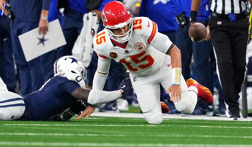 Dallas Cowboys linebacker DeMarvion Overshown, left, knocks the ball out of bounds away from Kansas City Chiefs quarterback Patrick Mahomes during the first half of an NFL football game Thursday, Nov. 27, 2025, in Arlington, Texas. (AP Photo/Tony Gutierrez)
