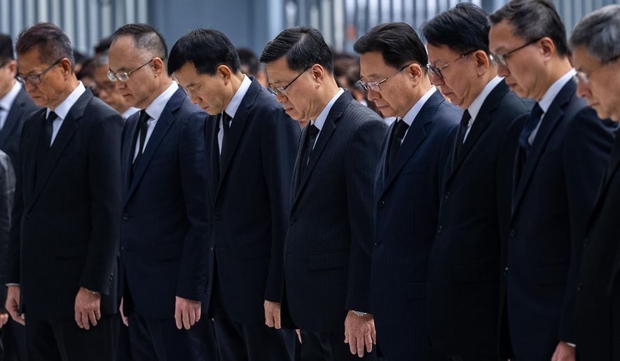 Hong Kong Chief Executive John lee, center and other officers observe a moment of silence for the victims of the deadly fire that started Wednesday at Wang Fuk Court, a residential estate in the Tai Po district of Hong Kong's New Territories, Saturday, Nov. 29, 2025. (AP Photo/Chan Long Hei)