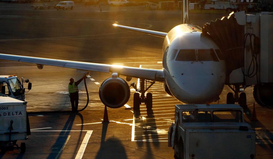 A worker fuels a passenger jet at Logan International Airport, Dec. 8, 2018, in Boston. (AP Photo/Bill Sikes, File)