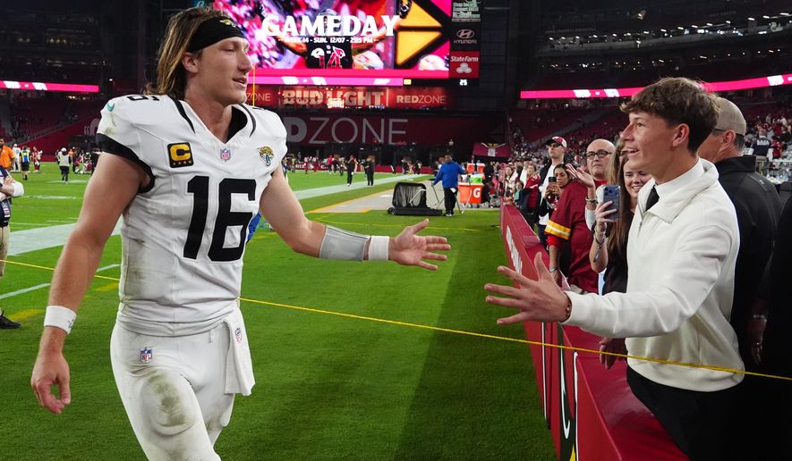 Jacksonville Jaguars quarterback Trevor Lawrence greets a fan as he leaves the field after an NFL football game against the Arizona Cardinals Sunday, Nov. 23, 2025, in Glendale, Ariz. (AP Photo/Ross D. Franklin)