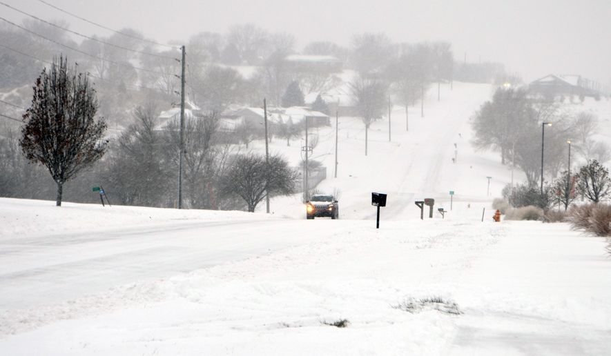 A car drives up a snowy Christy Road in the Sunnybrook neighborhood of Sioux City, Iowa, Saturday, Nov. 29, 2025. (Jared McNett /Sioux City Journal via AP)