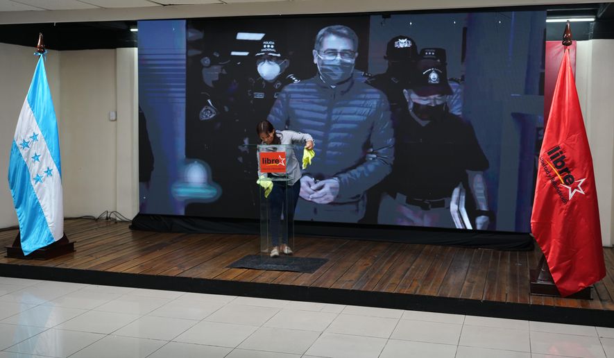 A screen displays an image of former Honduran President Juan Orlando Hernandez, a day after President Donald Trump said he plans to pardon Hernandez for a 2024 drug trafficking sentence, before the start of a press conference of Ruling party presidential candidate Rixi Moncada in Tegucigalpa, Honduras, Saturday, Nov. 29, 2025. (AP Photo/Moises Castillo)