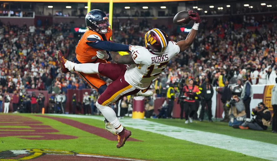 Washington Commanders wide receiver Treylon Burks (13) catches a touchdown pass as Denver Broncos cornerback Riley Moss, left, defends during the second half of an NFL football game Sunday, Nov. 30, 2025, in Landover, Md. (AP Photo/Stephanie Scarbrough)