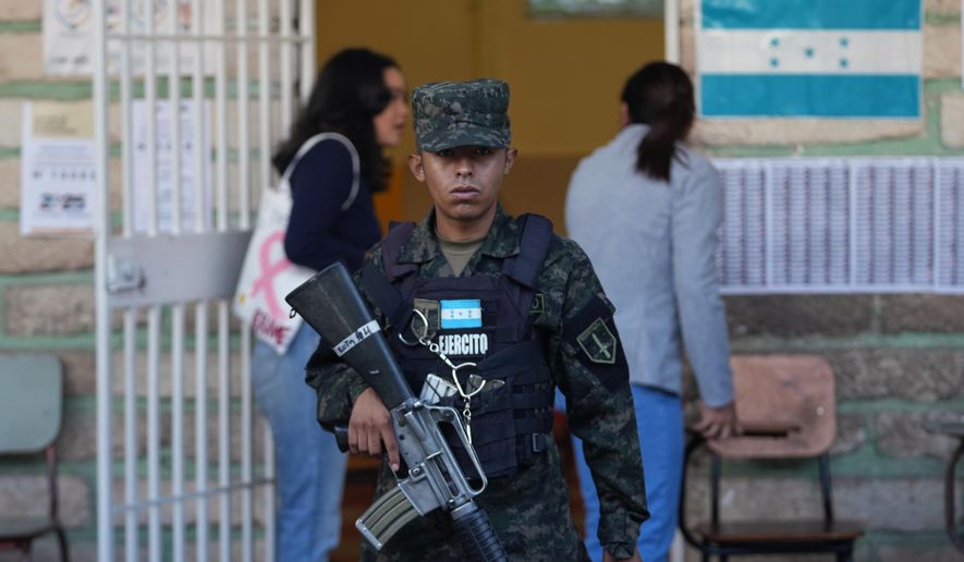 A soldier guards a polling station during general elections in Tegucigalpa, Honduras, Sunday, Nov. 30, 2025. (AP Photo/Moises Castillo)