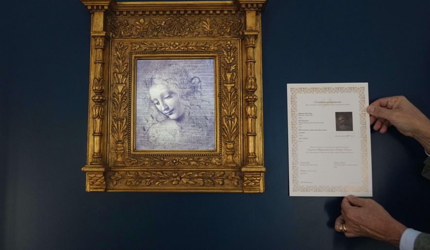 Primo Maronati holds a certificate next to a digital version of Leonardo Da Vinci's portrait, "La Scapiliata, Lady with Disheveled Hair," at the Brera Art Gallery in Milan, Italy, Monday, Nov. 24, 2025. (AP Photo/Antonio Calanni)
