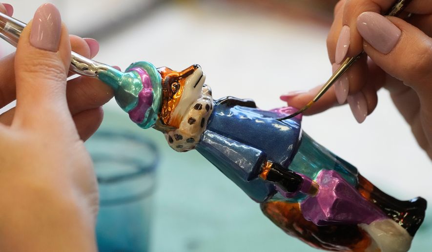 A worker prepares a hand-made Christmas bauble at GlitterLab in Czestochowa, southern Poland, on Nov. 21, 2025. (AP Photo/Czarek Sokolowski)