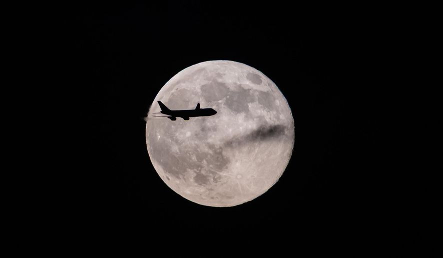 A UPS Boeing 747 inbound from Anchorage, Alaska, passes in front of the supermoon as it approaches Louisville Muhammad Ali International Airport on Wednesday, Nov. 5, 2025, in Louisville, Ky. (AP Photo/Jon Cherry)
