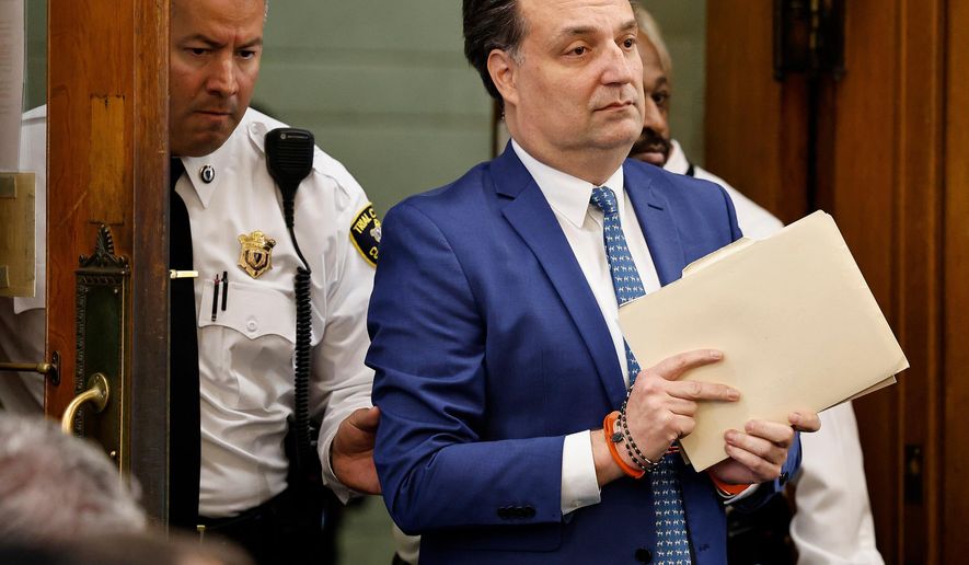 Brian Walshe enter the courtroom clutching papers and a rosary. Opening statements in the Brian Walshe murder trial in Norfolk Superior Court, Dedham, Mass., Monday, Dec. 1, 2025 (Greg Derr/The Patriot Ledger via AP, Pool)