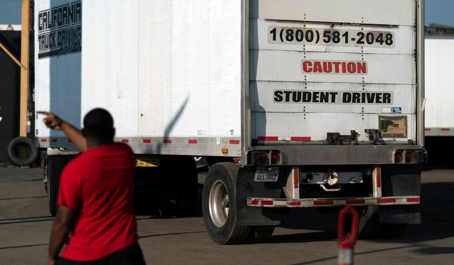 FILE - A student driver helps his classmate steer the wheel into the right direction as they practice driving in reverse in Calif., Nov. 17, 2021. (AP Photo/Jae C. Hong, File)