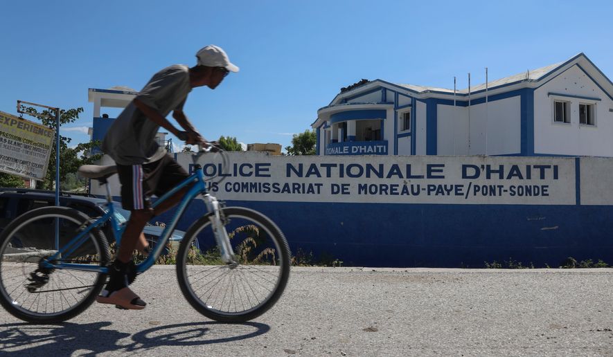 FILE - A man rides his bicycle past police station in Pont-Sonde, Haiti, Oct. 7, 2024. (AP Photo/Odelyn Joseph, File)