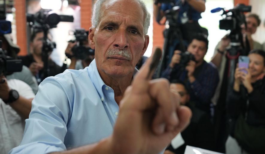 Nasry Asfura, presidential candidate for the National Party, shows his inked finger afterv voting in general elections in Tegucigalpa, Honduras, Sunday, Nov. 30, 2025. (AP Photo/Moises Castillo)