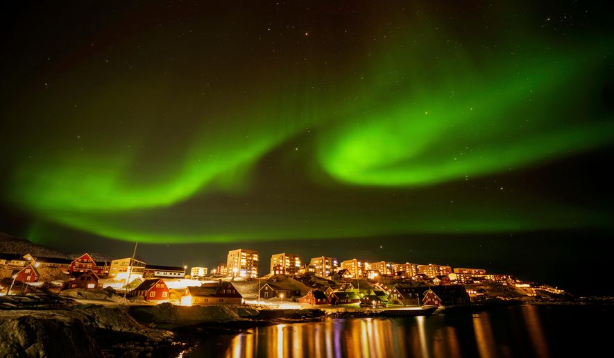 The Northern Lights shimmer over homes in Nuuk, Greenland, on Feb. 17, 2025. (AP Photo/Emilio Morenatti, File)