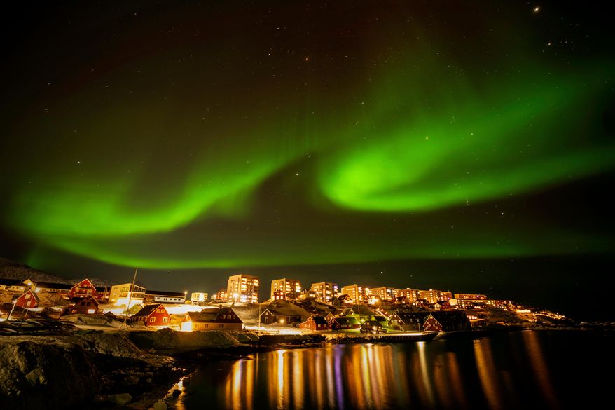The Northern Lights shimmer over homes in Nuuk, Greenland, on Feb. 17, 2025. (AP Photo/Emilio Morenatti, File)