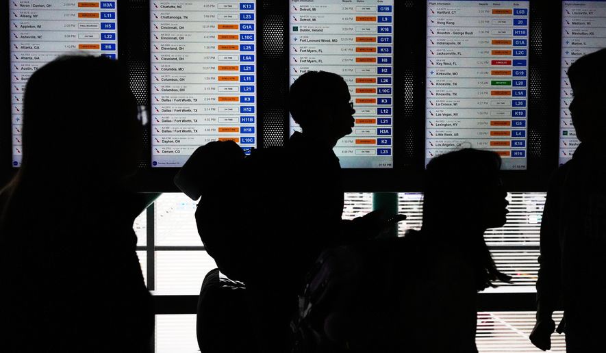 Travelers walk though the terminal at O'Hare International Airport, in Chicago, Sunday, Nov. 30, 2025. (AP Photo/Nam Y. Huh)