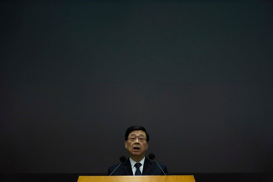 Hong Kong Chief Executive John Lee speaks during a press conference with a darken screen in the aftermath of a deadly fire in Hong Kong on Tuesday, Dec. 2, 2025. (AP Photo/Ng Han Guan)